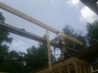 Carpenter setting a ridge beam over a new addition frame — Ice Dam Removal by Roofing Brothers in Boone Grove
