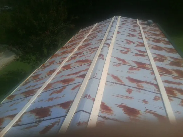 Rusted metal roof panels with new wood purlins before replacement — Storm Damage Roof Repair in Boone Grove by Roofing Brothers