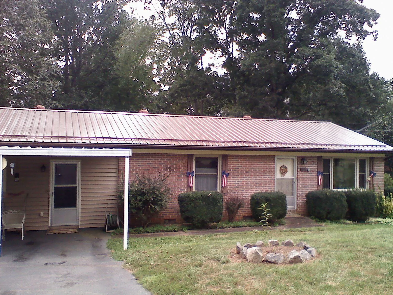 Bronze metal roof and carport on a brick ranch home — Roof Repair work by our crew in Boone Grove
