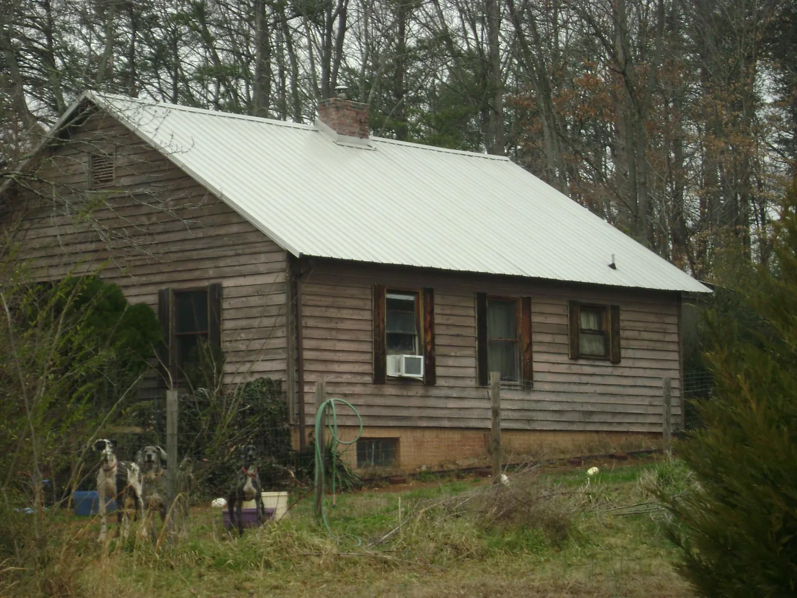 White metal roof on an old wood sided farmhouse, from a Metal Roof Installation job in Boone Grove